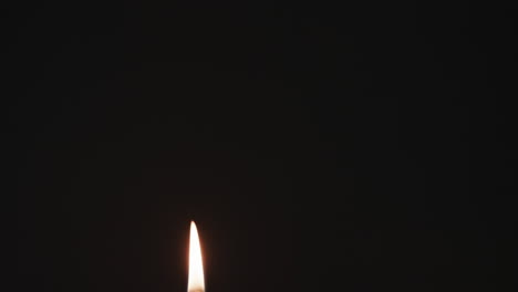 video of green candle with white flame and copy space on black background