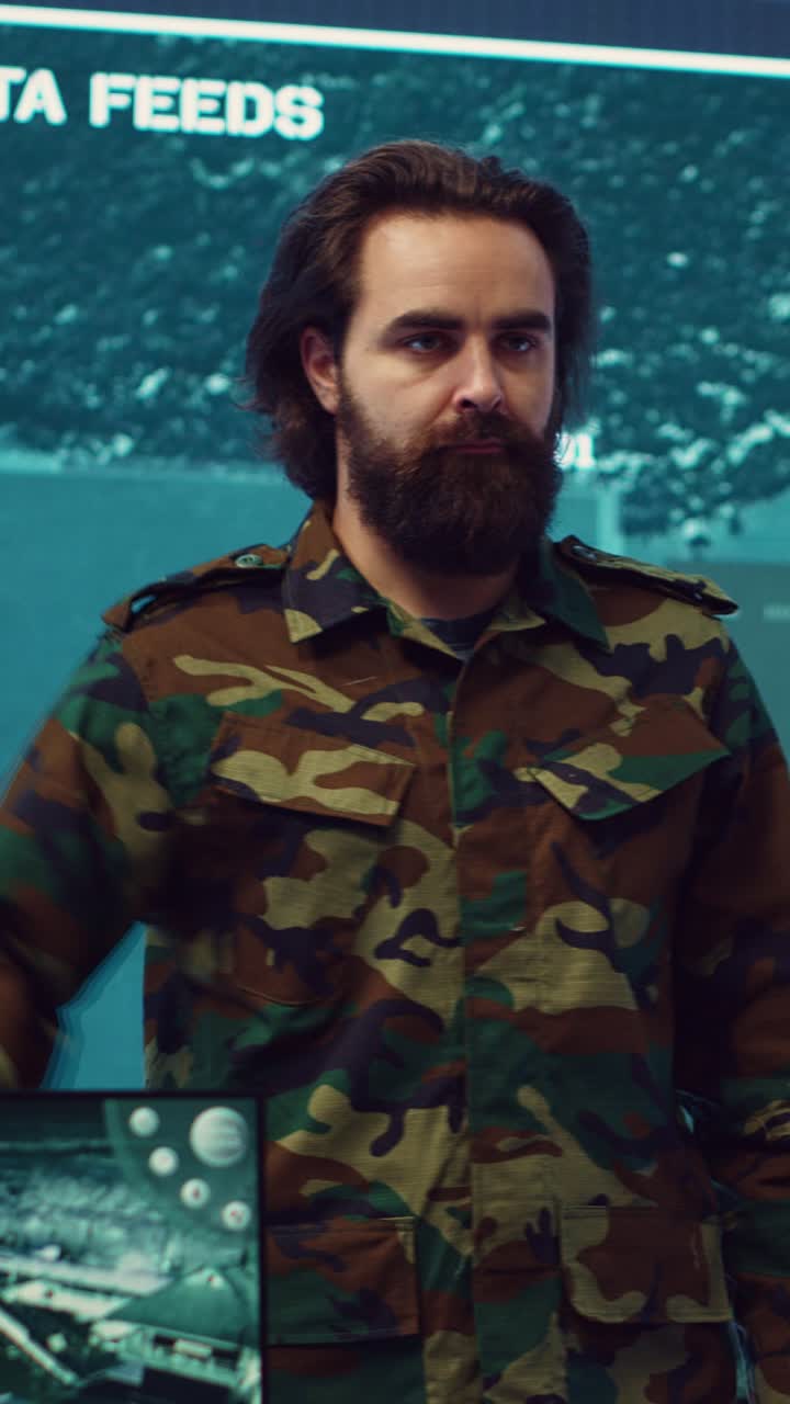 Uomo serio in uniforme mimetica che saluta nella sala di controllo