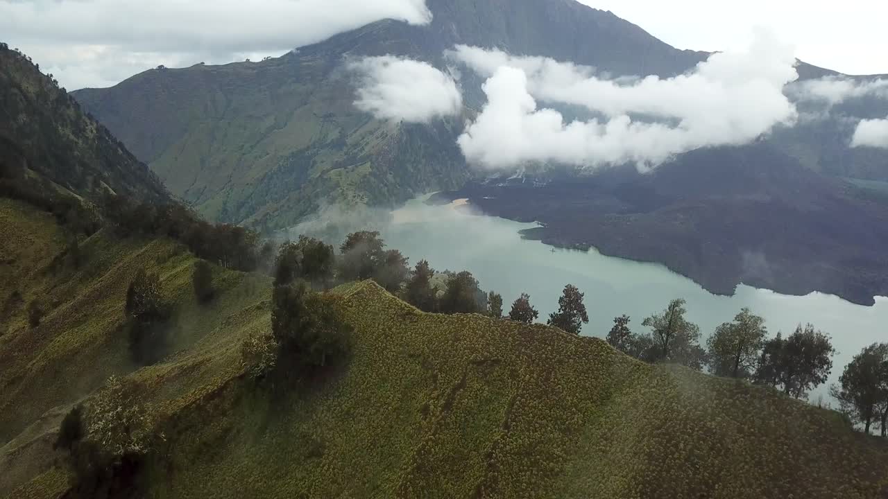 인도네시아 2번 뷰에서 분화구 호수가 있는 안개 낀 린자니 산의 공중 4k 패닝