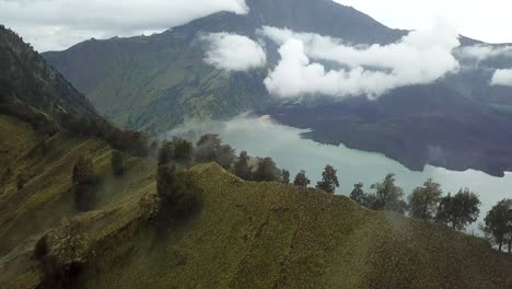 toma panorámica aérea 4k del monte rinjani con niebla con el lago del cráter en la vista 2, indonesia
