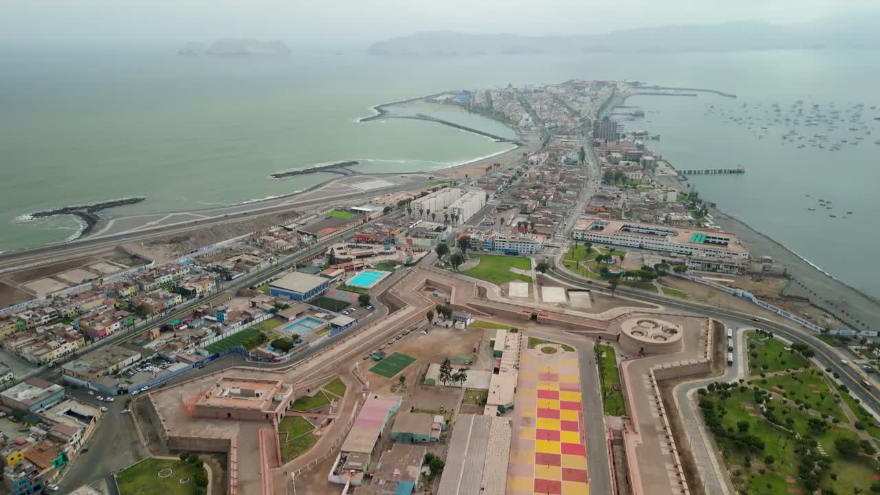 A high-altitude aerial shot tilts down to reveal the entire star-shaped layout of the historic Real Felipe Fortress, a massive colonial bastion protecting the port of Callao in Lima, Peru