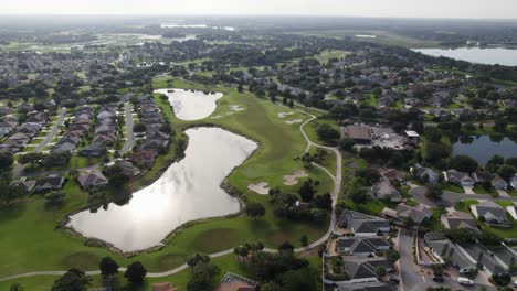 slow orbit drone shot of lush green golf course in florida senior living community