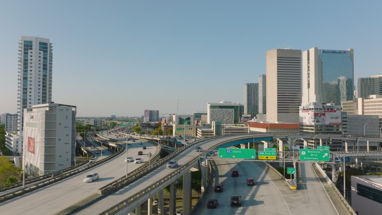 포워드는 도시의 큰 다층 및 다차선 고속도로 교차로 위를 날아갑니다. 고층 건물 사이의 무거운 교통. 마이애미, 미국