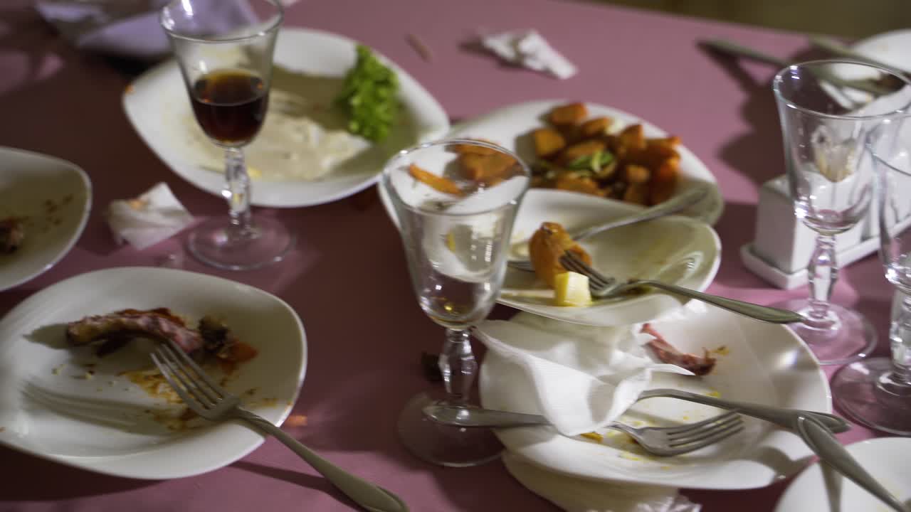 The leftover food and dirty dishes on the restaurant table.