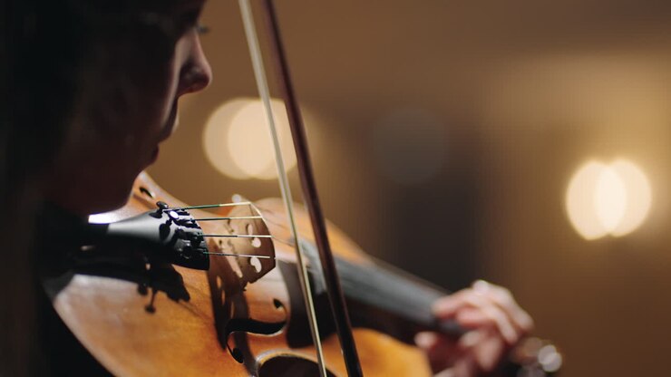 vista ravvicinata del violino nelle mani di una cantante donna violinista in un concerto di musica classica dell'opera