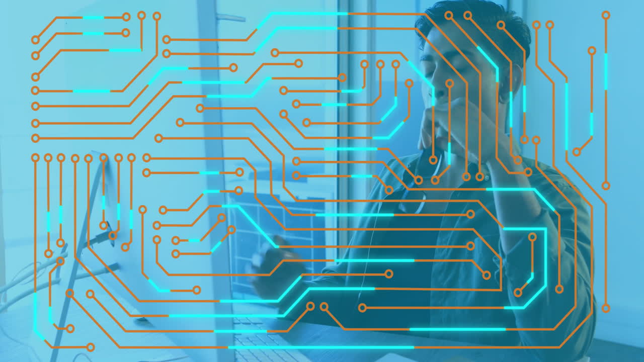 Animation of circuit board overlaying person working on computer in office
