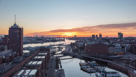 Schönes-Hamburg,-Deutschland-Während-Der-Goldenen-Stunde-Sonnenuntergang-Mit-Rotem-Himmel-Und-Blick-Auf-Vorbeifahrende-Boote-Im-Fluss-Und-Die-U-bahn,-Luftdrohnen-hyperlapse,-Zeitraffer-hyperlapse