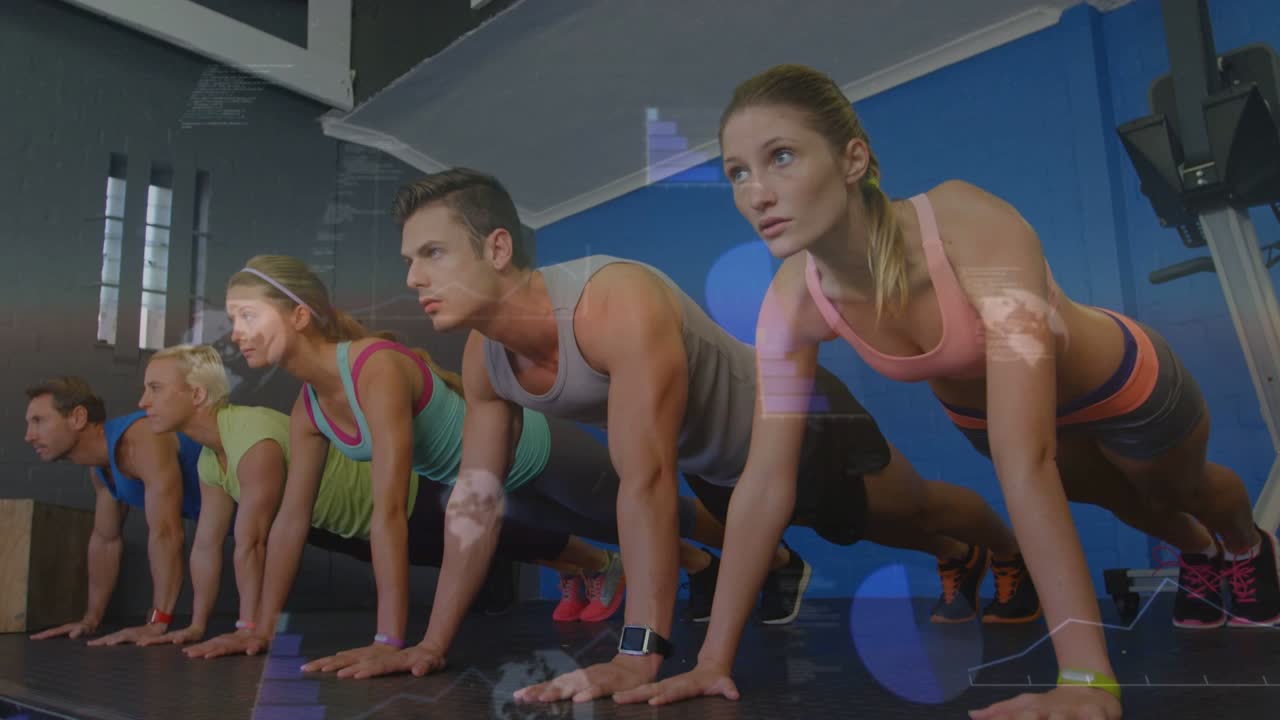 Vídeo vertical: Cinco adultos em fila fazendo flexões de prancha sincronizadas na academia, com contador mostrando repetições para a técnica.