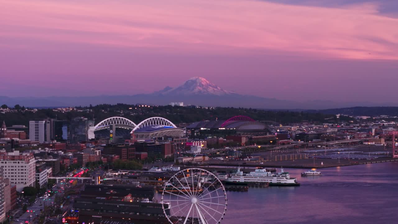 Aerial view of Mount Rainier looming over Seattle's downtown waterfront.