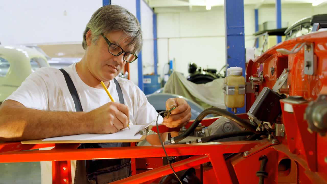 mecánico masculino escribiendo en el clipboard 4k