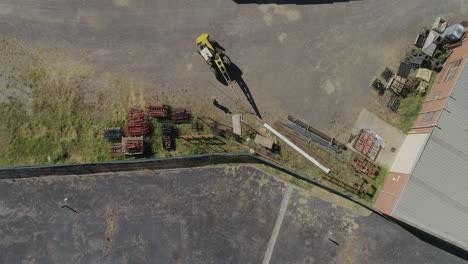 yellow mobile crane moving into position to find the next metal beam which needs moving into the nearby factory