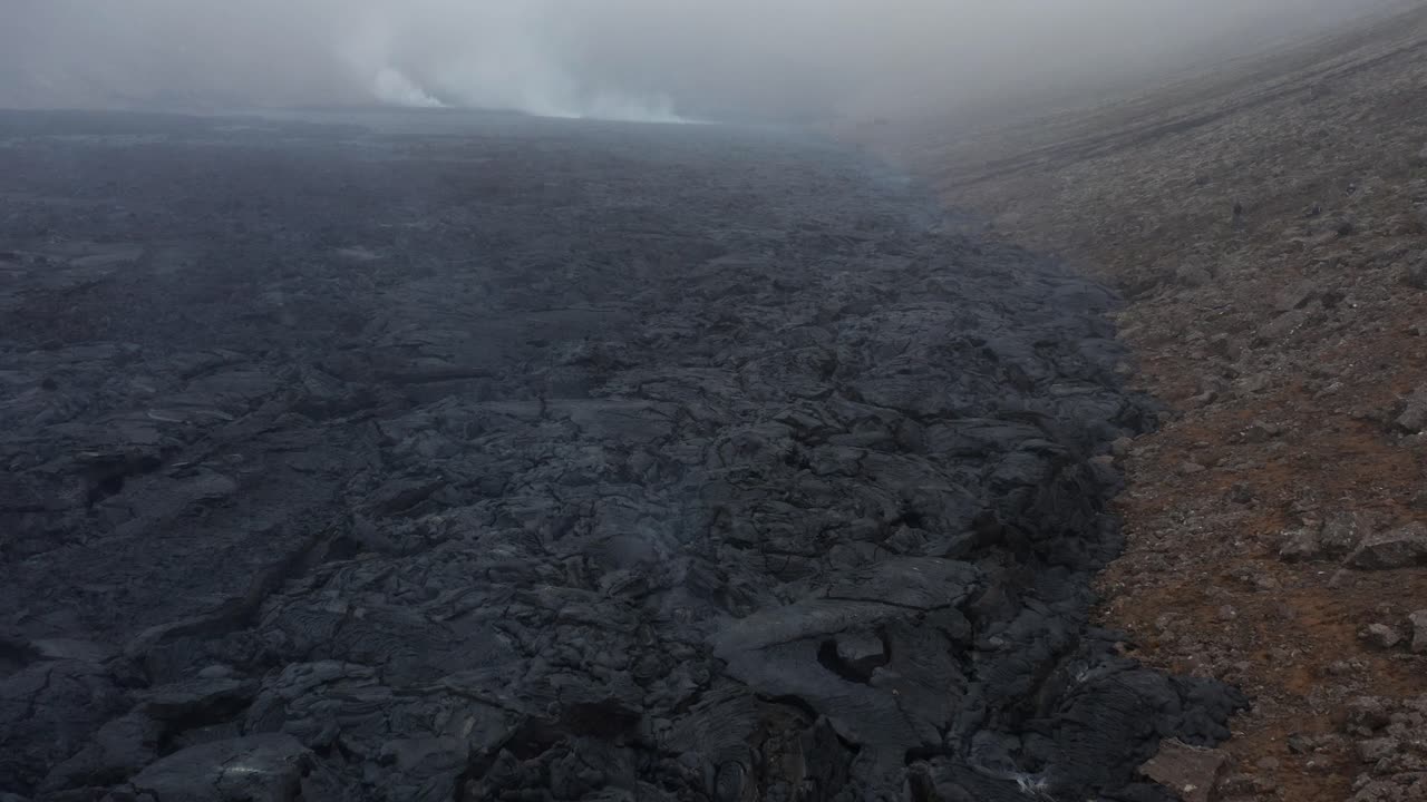 Freshly formed earth surface with black basalt rock in Iceland, cloudy