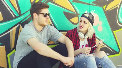 young hipster urban couple relaxing on a sidewalk