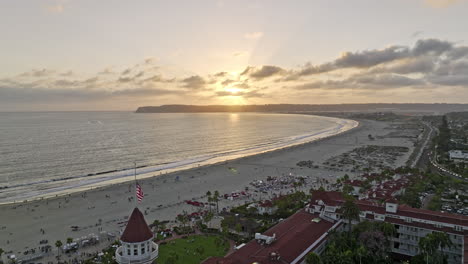 San-Diego-California-Antena-V104-Cinemático-Sobrevuelo-Inverso-Histórico-Hotel-Frente-A-La-Playa-Del-Coronado,-Resort-Victoriano-De-Madera-Con-Puesta-De-Sol-Debajo-Del-Punto-Loma---Filmado-Con-Cine-Mavic-3---Septiembre-De-2022