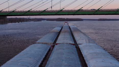 Drohnen-Luftaufnahmen-Eines-Riesigen-Lastkahns,-Der-Unter-Einer-Autobahnbrücke-Am-Mississippi-In-Der-Nähe-Von-Burlington-Iowa-Fährt