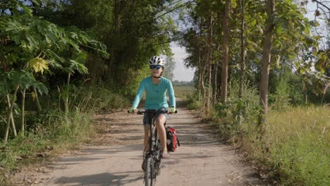 a stationary footage of a female cyclist riding her bike along an empty street in isan, thailand