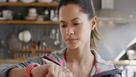 mujer de raza mixta comprobando el reloj inteligente para los objetivos de fitness