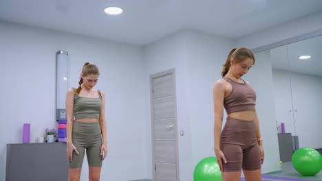 yoga-sitzung im gange mit dem fitnessstudio-direktor an der spitze, der die teilnehmer in koordinierten posen vor einem hintergrund von grünen ballons und verschiedenen fitnessstudio-geräten zeigt