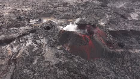 aerial view of an active volcanic crater with smoke and red lava in iceland.