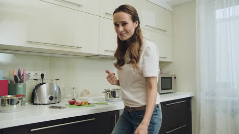 Mujer-Posando-Frente-A-La-Cámara.-Niña-Feliz-Cocinando-La-Cena-En-Casa