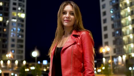 girando hermosa morena contra el fondo de una ciudad nocturna