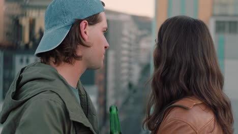 happy caucasian couple chatting enjoying rooftop view of city sharing connection drinking alcohol hanging out on weekend date at sunset