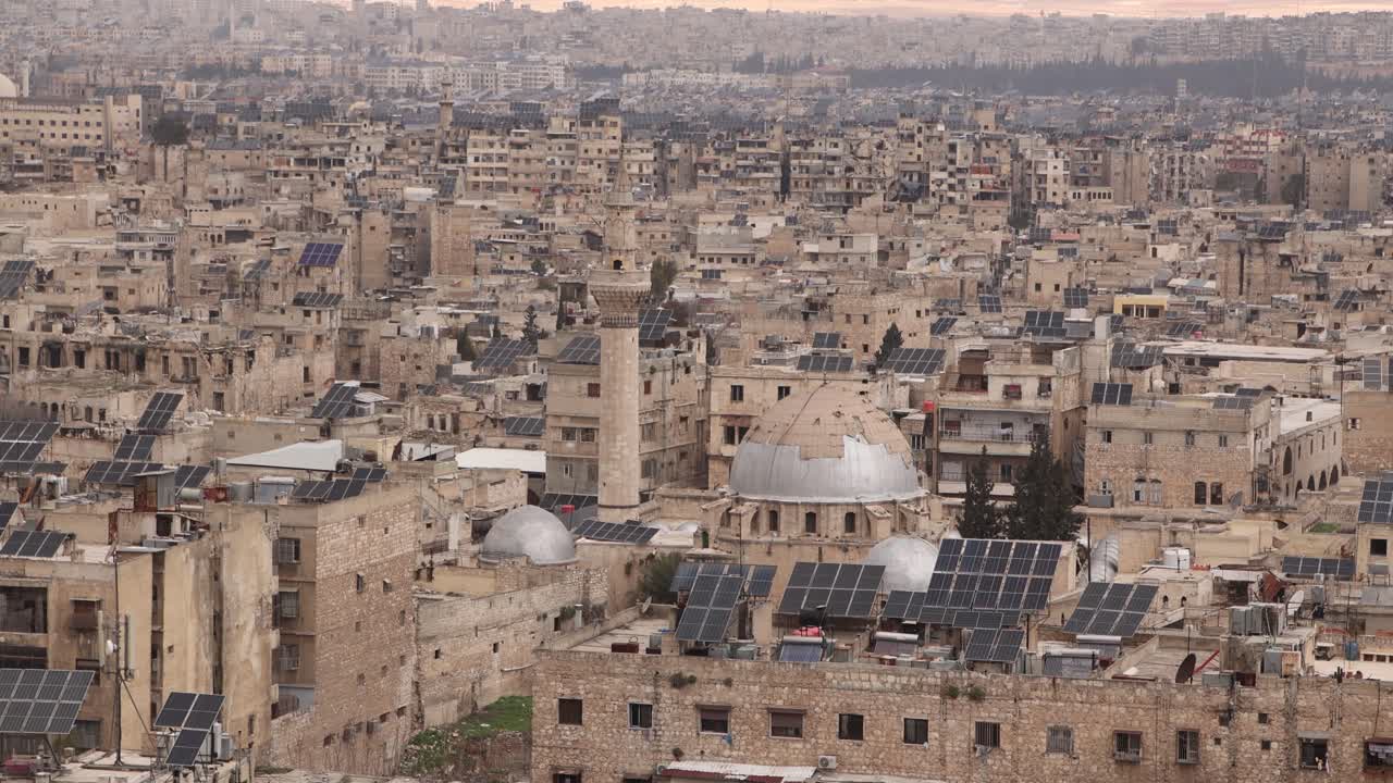 Veduta aerea della storica Città Vecchia di Aleppo, Siria, con tetti tradizionali e un'imponente cupola in pietra. Una testimonianza dell'antica architettura urbana e del patrimonio islamico.