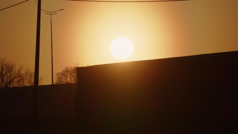 siluetas de camiones de contenedores con remolque de carga que conducen por la carretera transportando mercancías al atardecer.