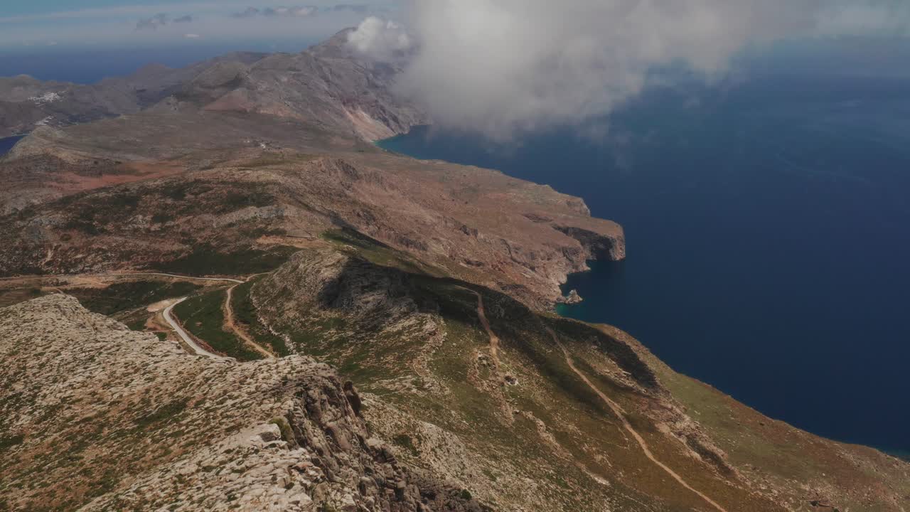 Beautiful landscape drone shot of in Greece on a rocky peak, Amorgos Island in cyclades Aegean Sea with beautiful panorama of blue ocean and mountains