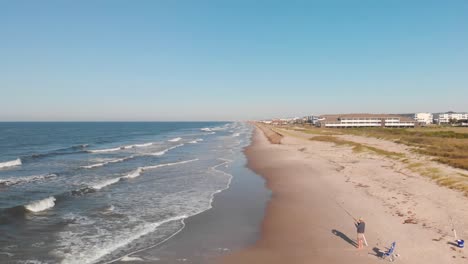 man fishing on beach in oak island nc in 4k