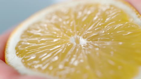 hand squeezing fresh juicy lemon close-up