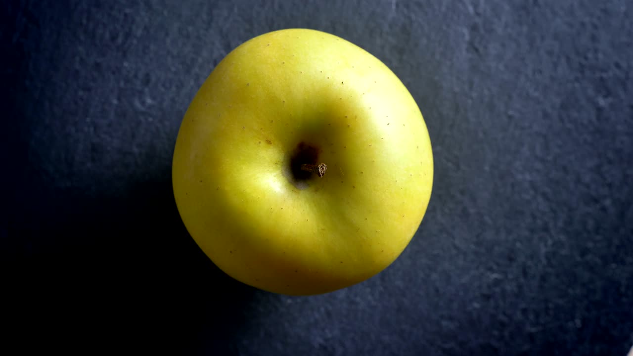 macro primer plano extremo de arriba hacia abajo disparo de saborosa manzana verde girando en movimiento