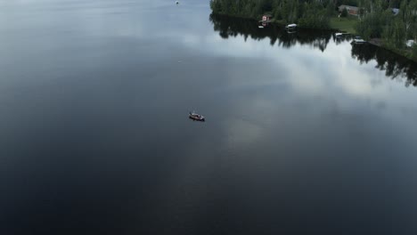 Pequeño-Barco-De-Pesca-Personal-Aéreo-En-Medio-De-Un-Lago-Tranquilo-A-Primera-Hora-De-La-Mañana