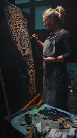 woman artist painting a leopard