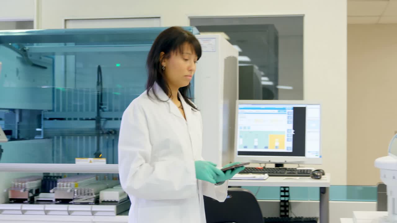 Científica usando una tableta digital en laboratorio 4k