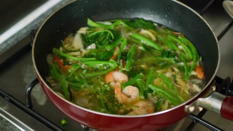 close up of cooking spinach and prawn in a cooking pan