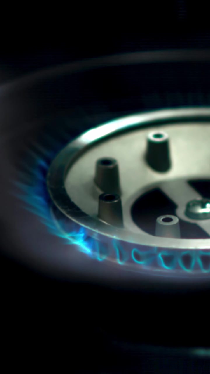 Bruciatore a gas che si accende con fiamma blu in un ambiente scuro