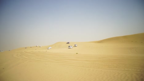coches blancos conduciendo en las dunas de arena