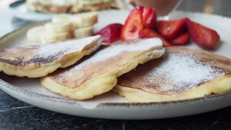 delicious pancakes with strawberries and banana for breakfast