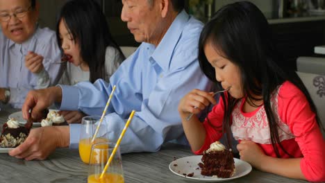 Seitenansicht-Einer-Asiatischen-Familie-Mit-Mehreren-Generationen,-Die-Am-Tisch-In-Einem-Komfortablen-Zuhause-4K-Geburtstagskuchen-Isst