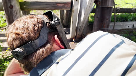 A-welder-wearing-a-protective-helmet-works-on-a-metal-project-outdoors