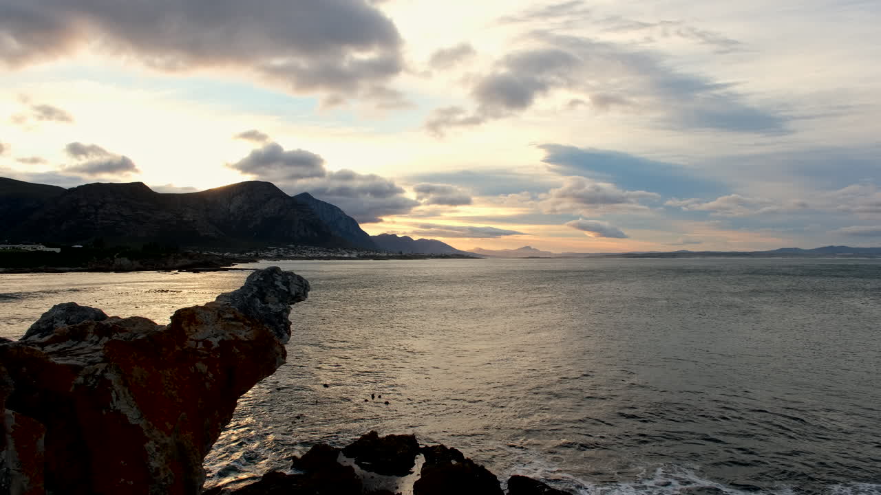 Scenic vibrant cloudscape over Walker Bay Hermanus with calm ocean at sunrise