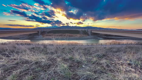 Time-lapse-from-between-the-highway-traffic-with-mountains-and-a-colorful-sunset-or-sunrise-in-the-background