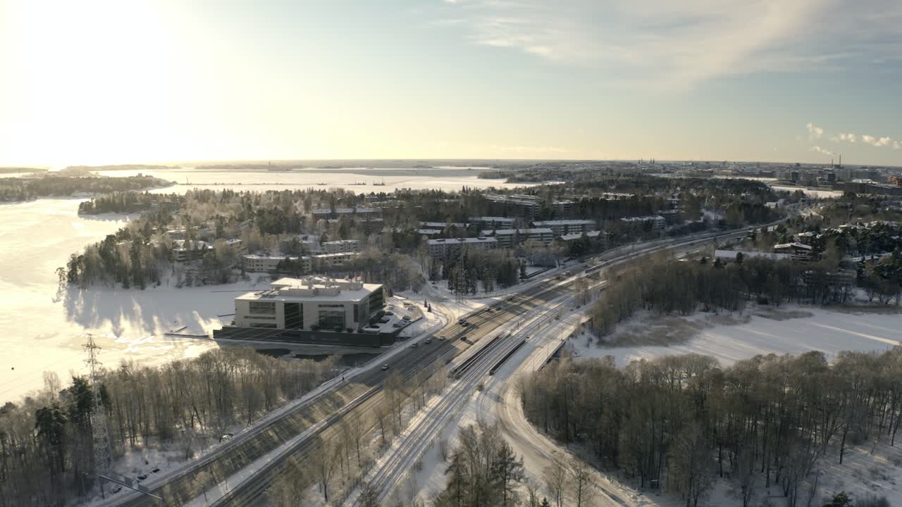 Aerial view following traffic on road 170, winter sunset in Herttoniemi, Helsinki