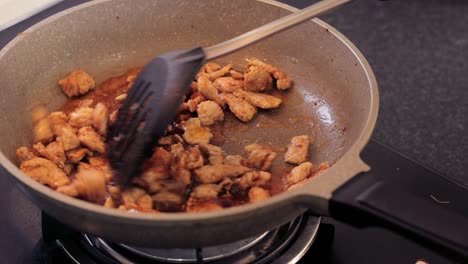 cocinar deliciosa carne de cerdo con azúcar y mezclar los sabores con un cucharón negro - cerrar