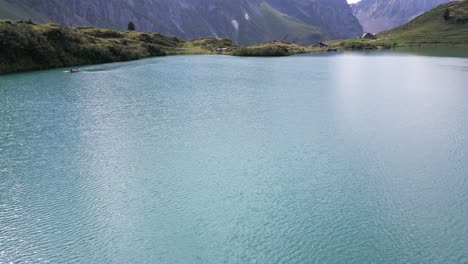 tilt up: vista aérea de drones de un lago alpino con montañas detrás en los alpes suizos en obwalden, engelberg