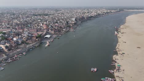 scenic drone shot capturing the densely packed housing of varanasi, where the ganges provides a spiritual anchor for the city's diverse communities.