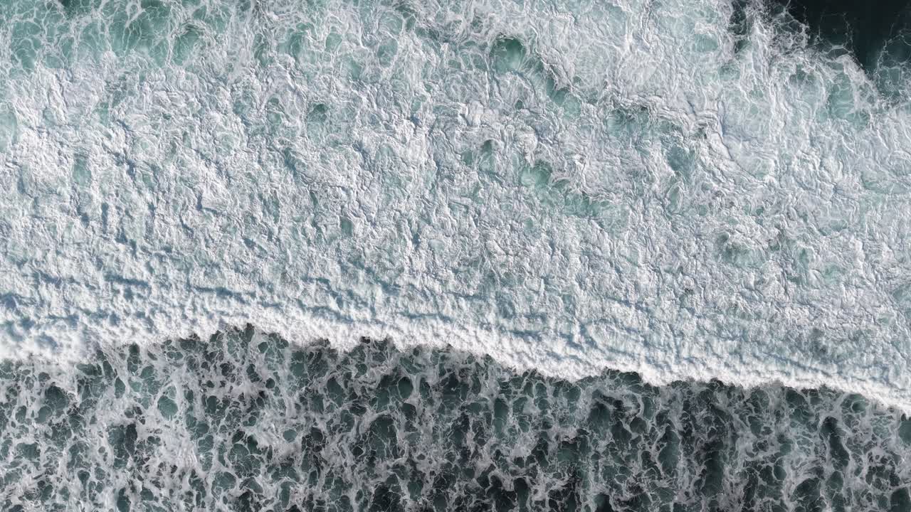 Aerial Top Down View of Ocean Waves Crashing and Foaming