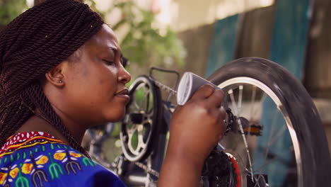 mujer lubricando una cadena de rueda de bicicleta