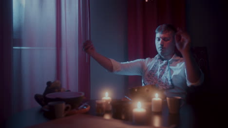 man eating dinner by candlelight at home